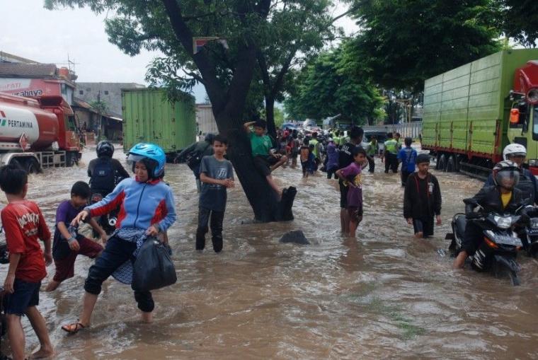 sejumlah kendaraan dan pejalan kaki berusaha melintasi banjir di Rancaekek