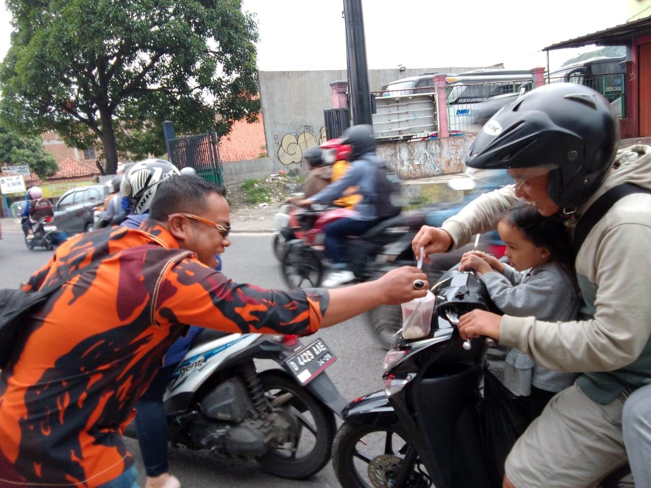 Ketua Pemuda Pancasila Ranting Cileunyi Kulon, Maman Abadi saat menyerahkan paket takjil kepada pengguna jalan